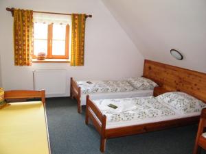 ヤンスケー・ラーズニェにあるChalupa u Smrčinyのベッド3台と窓が備わる客室です。