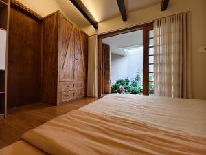 a bedroom with a large bed with a wooden door at Ansora Homestay Huế in Thôn An Hòa