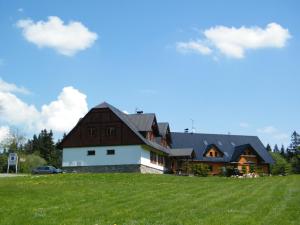 une grande maison au-dessus d'un champ verdoyant dans l'établissement Chalupa u Smrčiny, à Janské Lázně