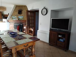 a living room with a table and a television at La petite Ginette in Serres
