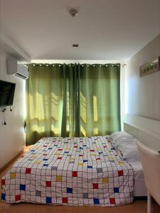 a bedroom with a bed with a quilt on it at Comfort Big condo in Chiang Mai +5 photos