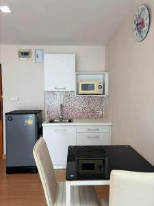 a small kitchen with a stove and a microwave at Comfort Big condo in Chiang Mai