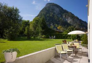 eine Terrasse mit einem Tisch, Stühlen und einem Berg in der Unterkunft Apart Blassnig in Maurach