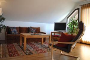 uma sala de estar com um sofá, uma mesa e uma televisão em Ferienwohnung Sonne em Bad Windsheim