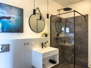a bathroom with a sink and a shower with a mirror at Seaside Retreat & Hotel in Stege +96 photos