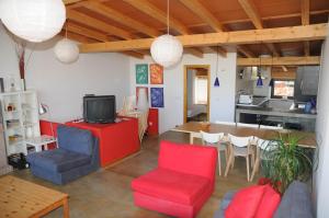 a living room with red and blue chairs and a table at Casa Rural El Bornizo con psicina jacuzzi climatizado barbacoa y jardín en Salamanca in Pastores