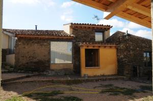 a house with a yellow hose in front of it at Casa Rural El Bornizo con psicina jacuzzi climatizado barbacoa y jardín en Salamanca in Pastores