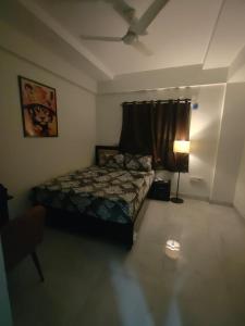 a bedroom with a bed and a lamp in it at Staywise in Indore +5 photos