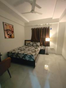 a bedroom with a bed and a ceiling fan at Staywise in Indore