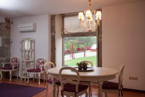 ein Esszimmer mit einem Tisch, Stühlen und einem Fenster in der Unterkunft Quinta do Cerqueiral in Arcos de Valdevez
