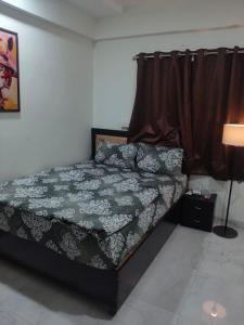 a bed sitting in a room with a curtain at Staywise in Indore