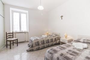 a bedroom with two beds and a chair and a window at Scala Center big holiday house in Scala +2 photos