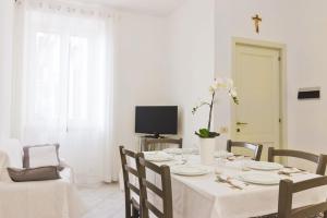 a white dining room with a white table and chairs at Scala Center big holiday house in Scala
