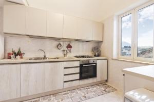 a kitchen with white cabinets and a sink and a stove at Scala Center big holiday house in Scala