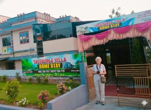 an older man standing in front of a building at Sree durga Villa Homestay in Kodoth