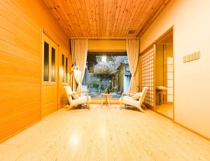 a living room with two chairs and a wooden ceiling at Hanastay Kawachinagano in Nagano