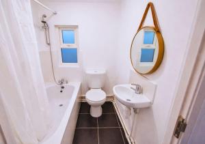 a bathroom with a toilet and a sink and a mirror at Matchday Mile House Walk to Anfield sleeps 8 in Liverpool