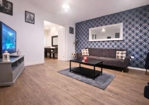 a living room with a couch and a tv at Matchday Mile House Walk to Anfield sleeps 8 in Liverpool