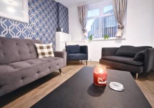 a living room with a couch and a table with a candle at Matchday Mile House Walk to Anfield sleeps 8 in Liverpool