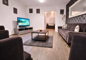 a living room with a couch and a tv at Matchday Mile House Walk to Anfield sleeps 8 in Liverpool