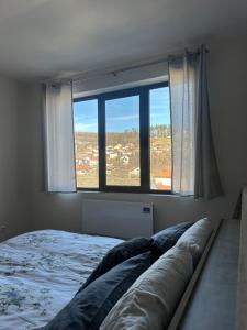 a bedroom with a bed and a large window at Tryavna Central Apartments-Harmony in Tryavna