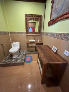 a bathroom with a toilet and a sink and a mirror at Amelia Villa in Montongbuwoh