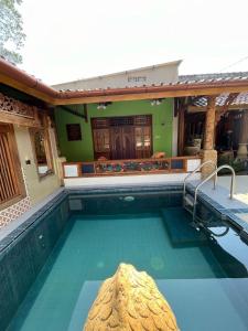 a swimming pool in front of a house at Amelia Villa in Montongbuwoh