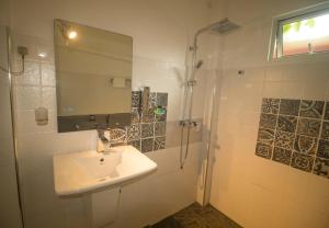 a white bathroom with a sink and a shower at Suriya Homestay Mirissa in Mirissa