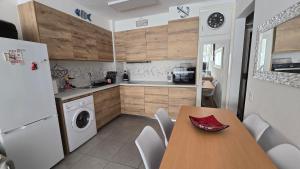 a kitchen with a table and a white refrigerator at Rosas in Roses