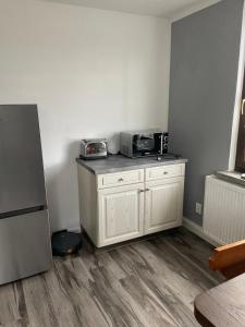 a kitchen with a microwave on top of a counter at Mila's Fewo in Stollberg +1 photo