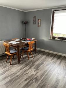 a dining room with a wooden table and two chairs at Mila's Fewo in Stollberg