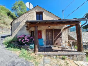 a small stone house with a deck and a door at Maison au calme entre Causses and Cévennes in Barre-des-Cévennes