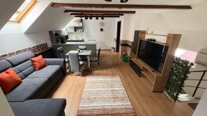 a living room with a couch and a television at My Central Home in Miercurea-Ciuc