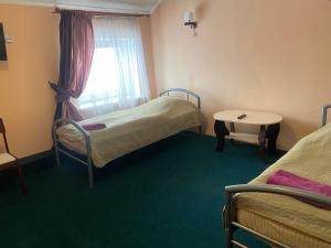 a room with two beds and a table and a window at Avtoport Restorant Hotel Complex in Vinnytsya