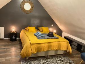 a bedroom with a yellow bed with yellow pillows at Loft Le Petit Solognot in Mont-près-Chambord