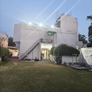 a white building with a spiral staircase in a yard at Ruchi resort in Hisār