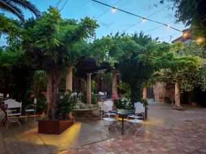 a patio with a table and chairs and trees at Hotel Boutique Palacio de la Serna in Ballesteros de Calatrava