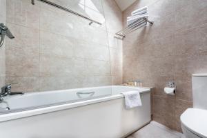 a bathroom with a bath tub and a toilet at Woodenbridge Hotel in Arklow