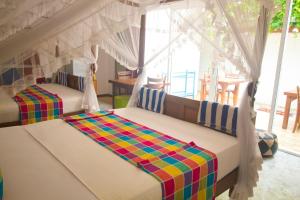 a bedroom with two beds in a room at Suriya Homestay Mirissa in Mirissa