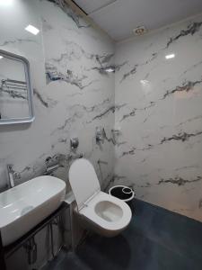 a bathroom with a white toilet and a sink at Hotel Regal Gate in Mumbai