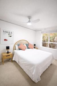 a bedroom with a white bed and a window at Moonya Courtyard in Carnegie
