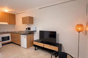 a small kitchen with a television and a table with a table sidx sidx at Moonya Courtyard in Carnegie +4 photos