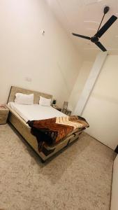 a bed in a room with a ceiling fan at Hotel Indian Lemon Tree in Jīnd