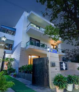 a large white building with a fence in front of it at The Hotel Am Bliss in Gurgaon