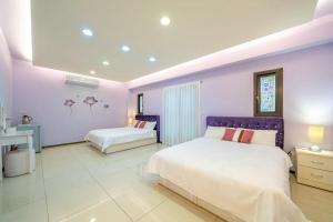 a bedroom with two beds and a purple wall at 窩心の家民宿 in Suao
