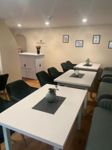 a waiting room with white tables and green chairs at Die Meissen Lodge in Meißen
