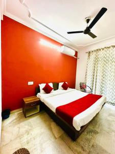 a bedroom with a bed with a red wall at Angel paradise in Jaipur