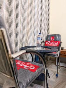 a table and two chairs with a bottle of coke at Angel paradise in Jaipur