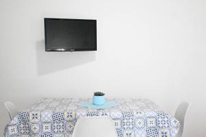 a dining room table with a tv on the wall at Casa Vacanze Zefiro in Marzocca di Senigallia