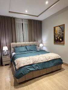 a bedroom with a large bed with blue pillows at Khobar Luxury Apartments in Al Khobar